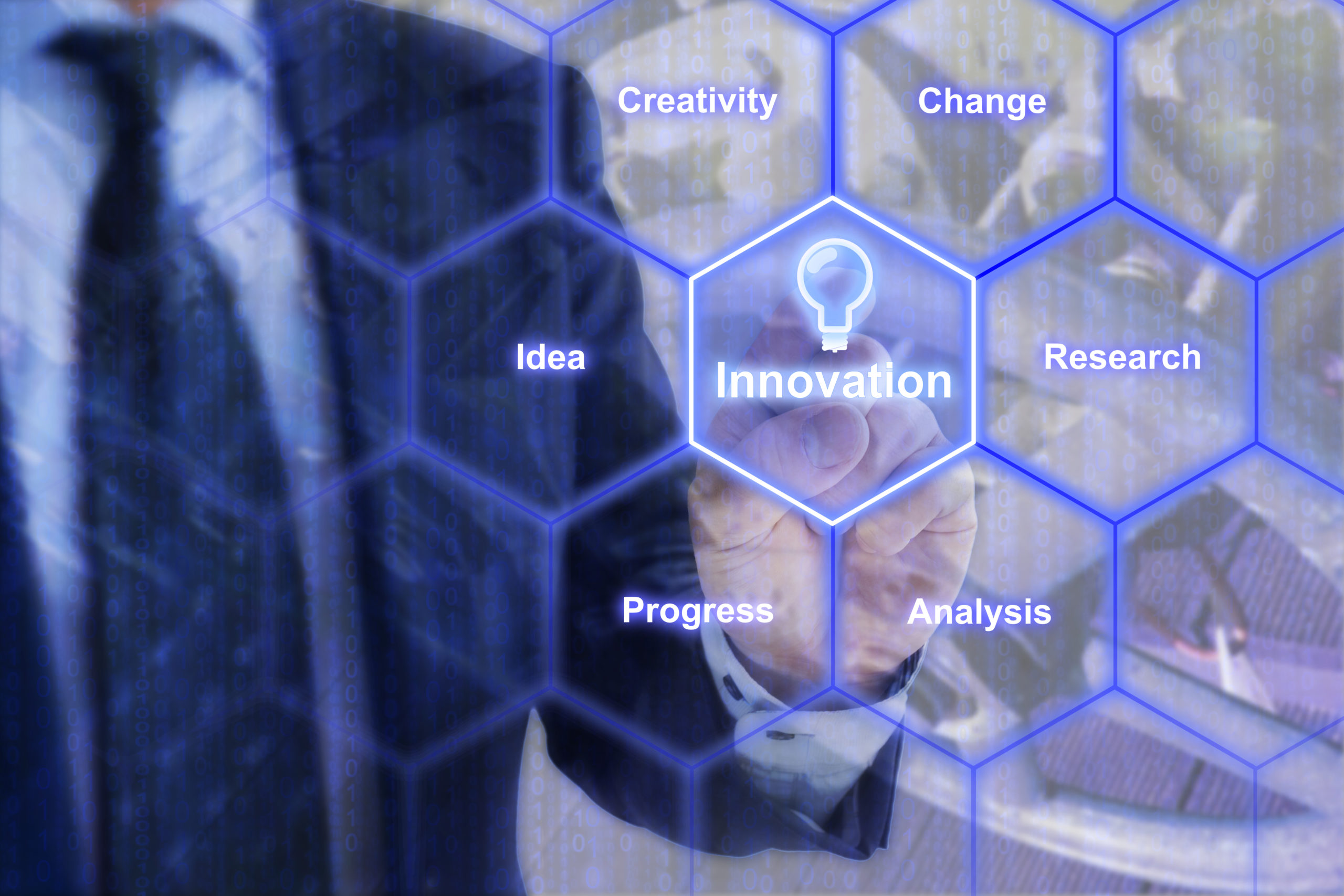 Businessman in blue suit touching a hexagon grid with innovation keywords